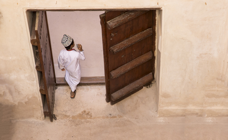 Jibreen, Oman, Febrary 2nd, 2018: omani kid walking through old doors at a castleのeditorial素材