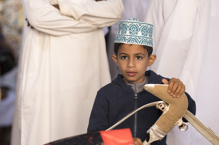 nizwa, Oman, Febrary 2nd, 2018: omani kid at a  market holding a khanjar knifeのeditorial素材