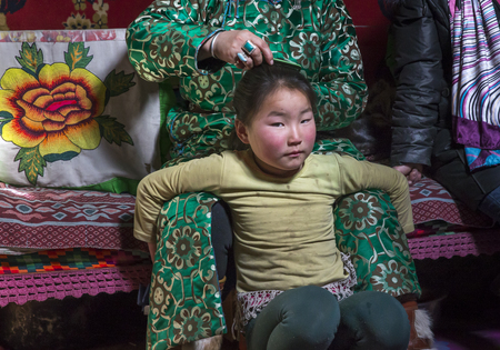 Hatgal, Mongolia, 2nd March 2018: mongolian girl inside her home ger with her mother combing her hairのeditorial素材