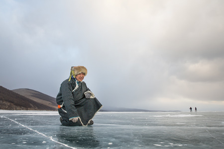 Hatgal, Mongolia, 3rd March 2018: mongolian man dressed in traditional clothing on frozen lake Khovsgolのeditorial素材