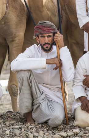 Ibri, Oman, April 7th, 2018: omani man with camels in a countryside roadのeditorial素材