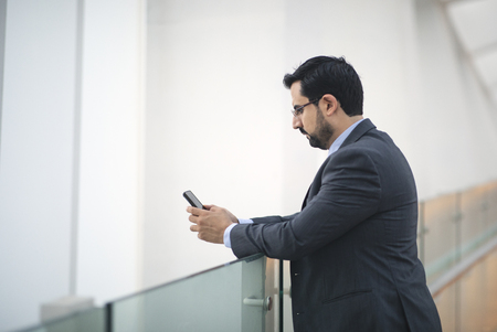 middle aged arab man texting on his phoneの写真素材