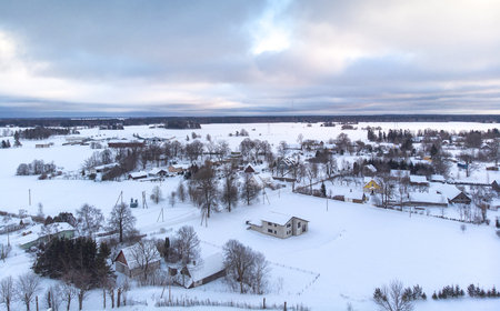 houses in a snowy field in a Pajusti Village in Estoniaの写真素材
