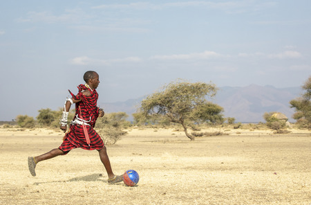 Arusha, Tanzania, 7th September 2019: maasai warriors playing football in savannahのeditorial素材