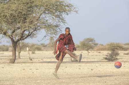 Arusha, Tanzania, 7th September 2019: maasai warriors playing football in savannahのeditorial素材