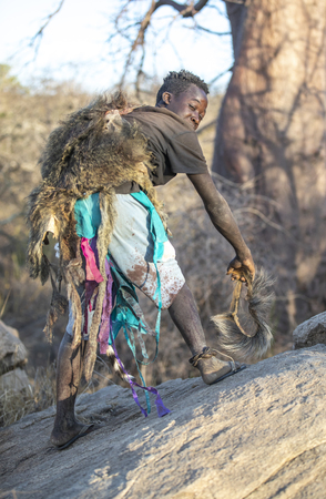 lake Eyasi, Tanzania, 11th September 2019: hadzabe man showing how baboons walkのeditorial素材