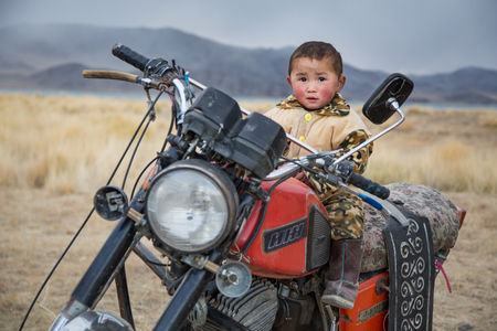 Bayan-Olgii, Mongolia, September 2014: mongolian kid on a motobikeのeditorial素材