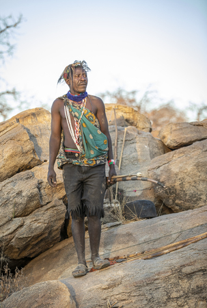 Lake Eyasi, Tanzania, 11th September 2019: Hadzabe man on a rock with his bow and arrowsのeditorial素材