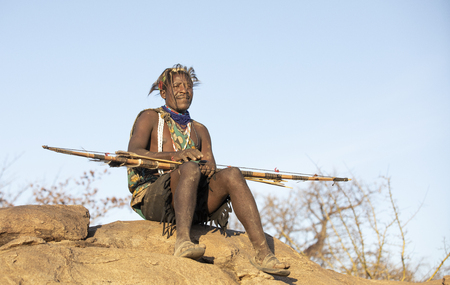 Lake Eyasi, Tanzania, 11th September 2019: Hadzabe man resting with his bow and arrowのeditorial素材