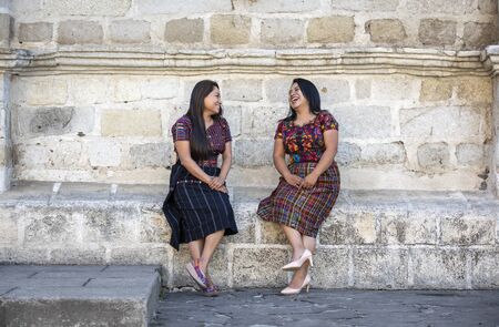 two mayan ladies in their traditional clothing, chatting outdoorsの写真素材