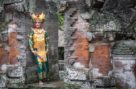 balinese legong dancer in traditional outfit in old temple ruins in Baliの写真素材