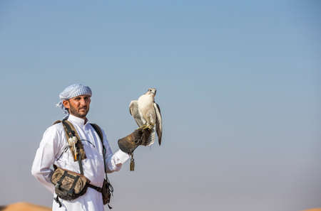 Dubai, United Arab Emirates, 18th November 2016: falconer with his falcon in a deser