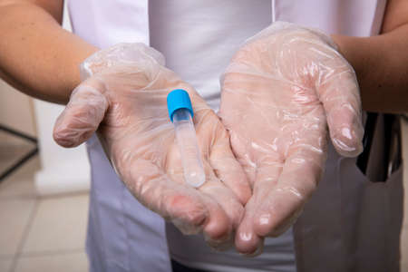 Hands holding a vial of vaccine