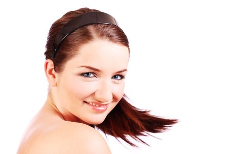A beautiful young woman turning her head toward the camera and smiling.の写真素材