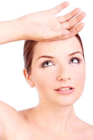 A pretty young woman with her hand to her head on a white background.の写真素材