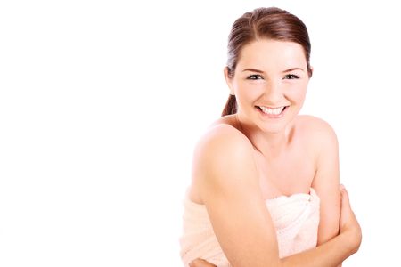 A smiling woman holding a bath towel around herself and smiling cheekily to the camera.の写真素材