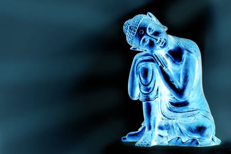 A glowing Buddha statue resting, in front of a blue abstract background with a の写真素材