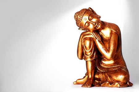 A Buddha statue resting, in front of a gray background with a spotlight.の写真素材
