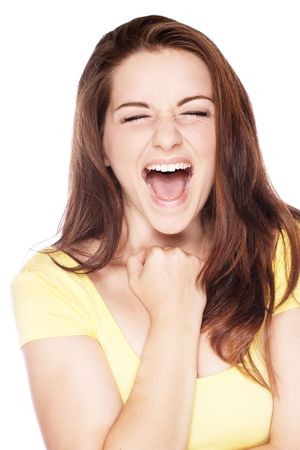 A beautiful young woman fist pumping and screaming as if she has had some good news.の写真素材