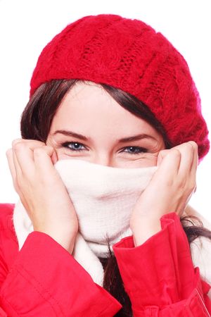 A close up of a woman wearing a hat and scarf, pulling the scarf up over her face, on a white background.の写真素材