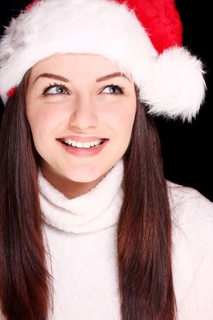 A pretty young woman wearing a santa hat on a black background.の写真素材