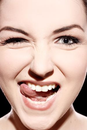 A close up of a young woman pulling a ridiculous face.の写真素材
