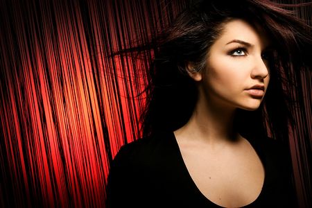 A beautiful young woman looking away with her hair in motion.の写真素材