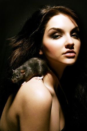 A beautiful young woman with a rat on her shoulder.の写真素材