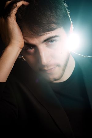 A gorgeous young man backlit and looking at the camera.