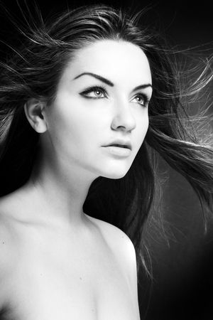 A beauty shot of a young blue eyed woman with her hair flowing in the wind. Black and white.の写真素材