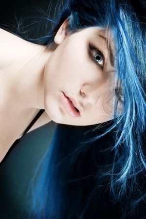 An abstract portrait of a young woman with electric blue hair and eyes.の写真素材