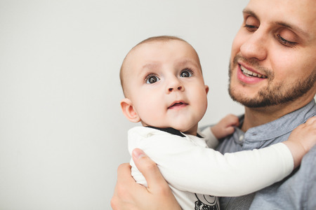 Young happy father holding baby son in hands and smile with isolated の写真素材
