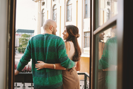 Young couple standing at the balcony of the hotel room in a dayの写真素材