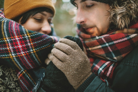 Young hipster couple having a date in winter forestの写真素材
