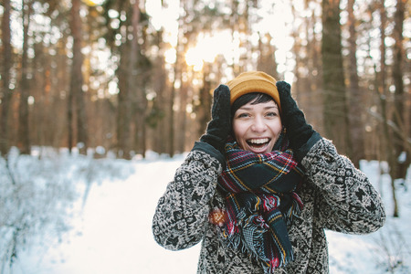 Young hipster woman in winter forest having funの写真素材