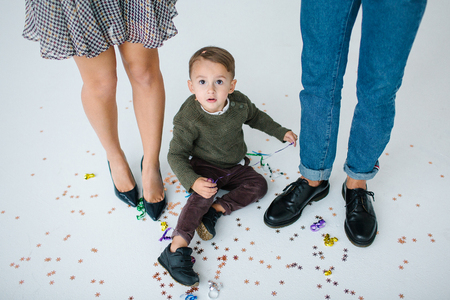 Young family of mother father and son celebrating with confetti over white backgroundの写真素材