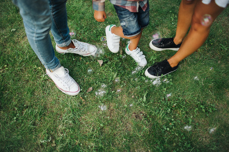 Legs of man woman and child on green grass outdoorsの写真素材