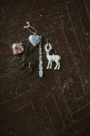 Old fashioned Christmas tree toys in shape of heart and deer on the wooden floorの写真素材