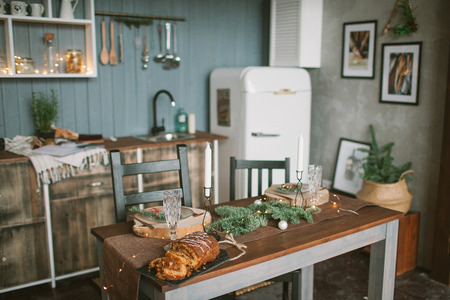 Beautiful holiday decorated loft kitchen with Christmas cake on the tableの写真素材