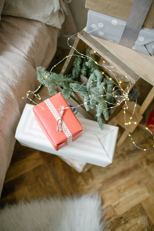 Christmas gifts in boxes on the floor with pine tree branchの写真素材