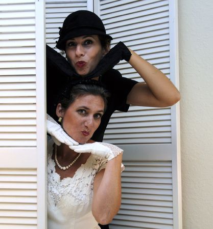 Two dressed up women blowing kisses at the camera