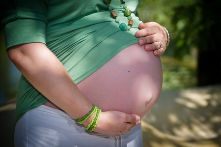 belly of pregnant woman, with hands holding bellyの写真素材