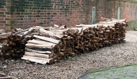 Large pile of chopped wood, stored in rows to be used for fire wood