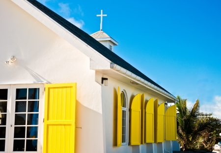 White church building with bright yellow window shudders in Hope Town, Abaco, Bahamasの写真素材