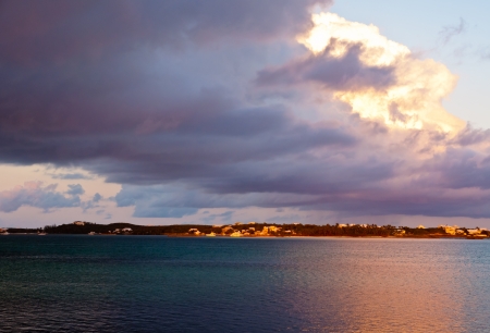 Gray storm clouds over the ocean with the sun beaming through on one sideの写真素材