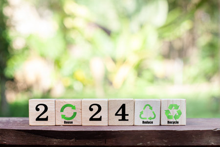 New Goals, Plans and Visions for Next Year 2024. Number 2024 and green business icons on wooden cube. Concept of green business, environmental sustainability target, ESG, Co2, SDGs, and NetZero.の写真素材