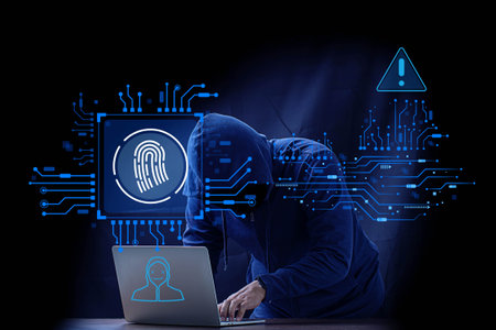 A hacker in a hoodie stealing personal data from a laptop. Dark background.の写真素材