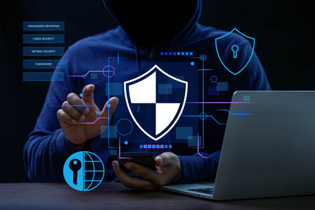 Hacker using smartphone and laptop with cyber security concept on dark backgroundの写真素材