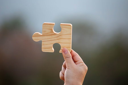 Business success and strategy solutions concept,Hands woman connect couple puzzle piece together with sunlight backgroundの写真素材