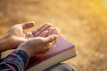 Man hands praying to god with the bible. Believe in goodness. Holding hands in prayer. Power of hope...